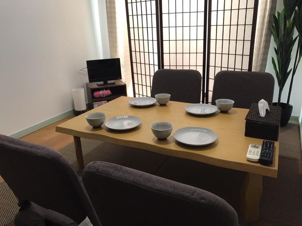 a wooden table with plates and bowls on it at Vintage III - Vacation STAY 14907 in Fukuoka