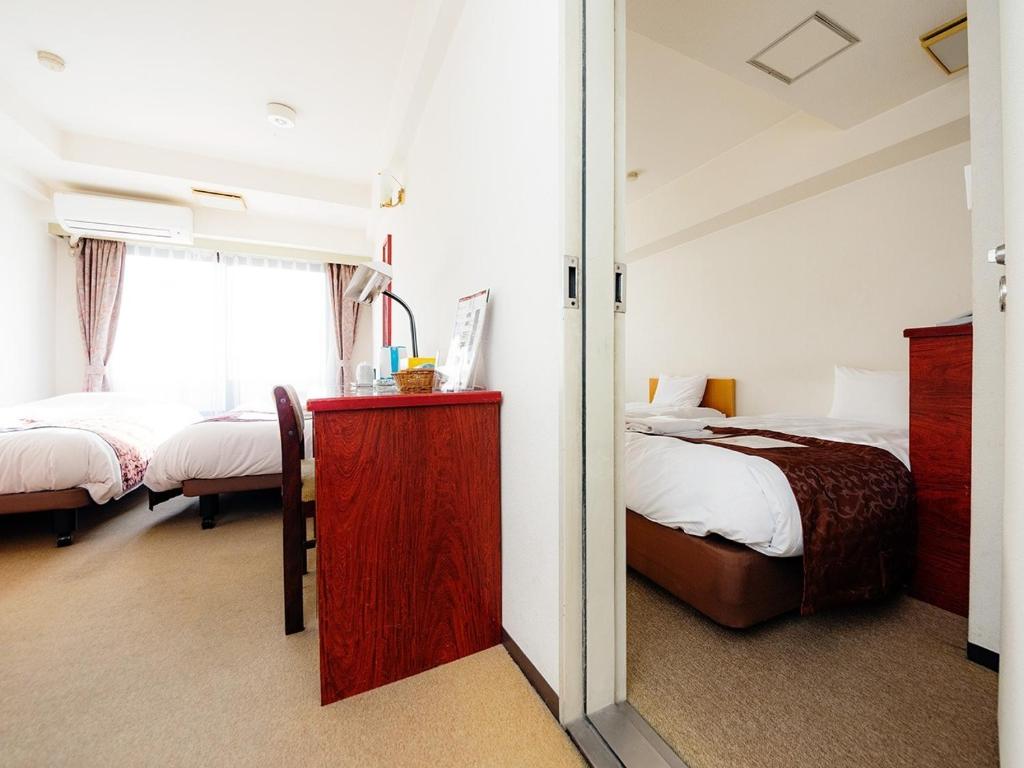 a bedroom with two beds and a mirror at Sky Heart Hotel Koiwa - Vacation STAY 51656v in Tokyo