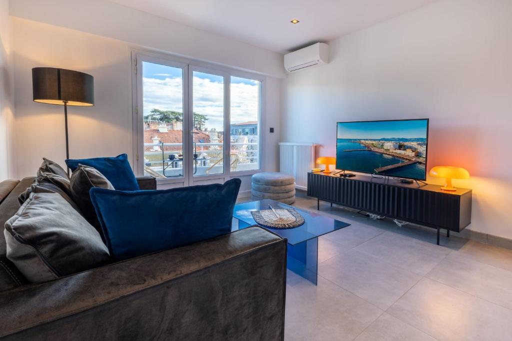 un salon avec un canapé et une télévision dans l'établissement 06AZ - Apartment with terrace - 10min from Palais, à Cannes