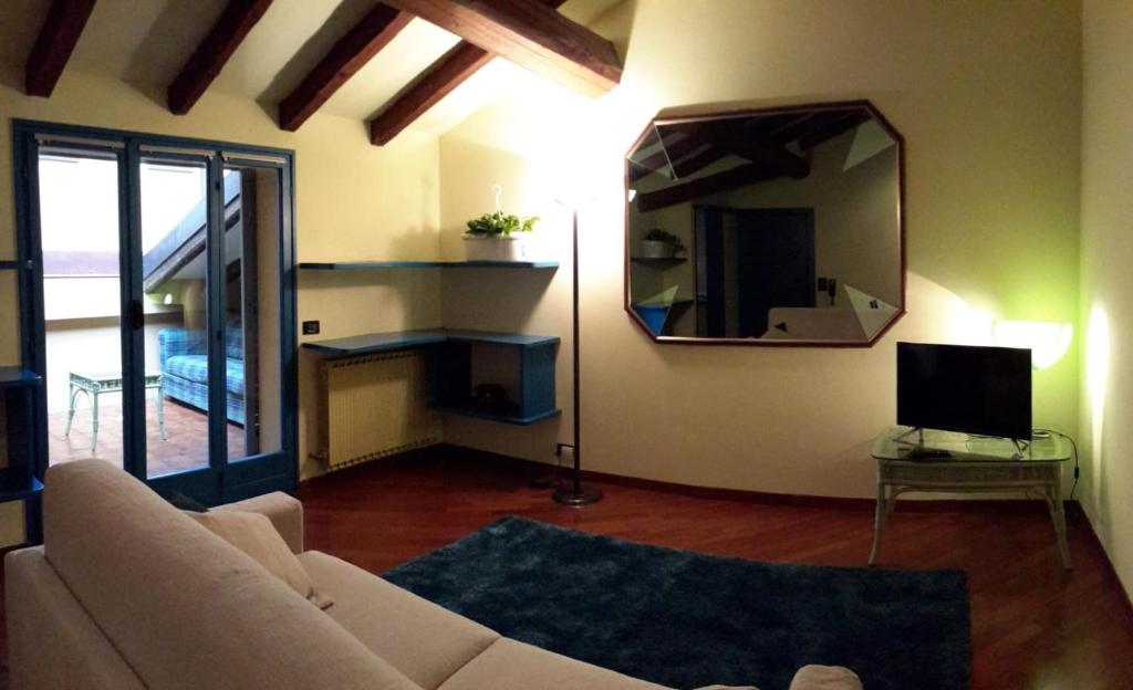 a living room with a white couch and a mirror at Fuori Portico Orso in Bologna