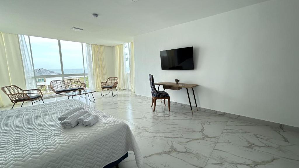 a bedroom with a bed and a table and a television at Hotel Presidente Beach Playas in Playas