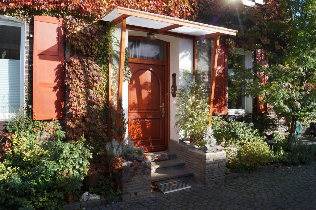 una casa con una porta rossa e edera di Hof am Rhein a Colonia