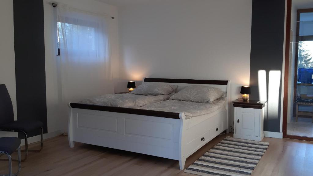 um quarto com uma cama branca com 2 candeeiros em Zimmer mit Aussicht em Schulenberg im Oberharz