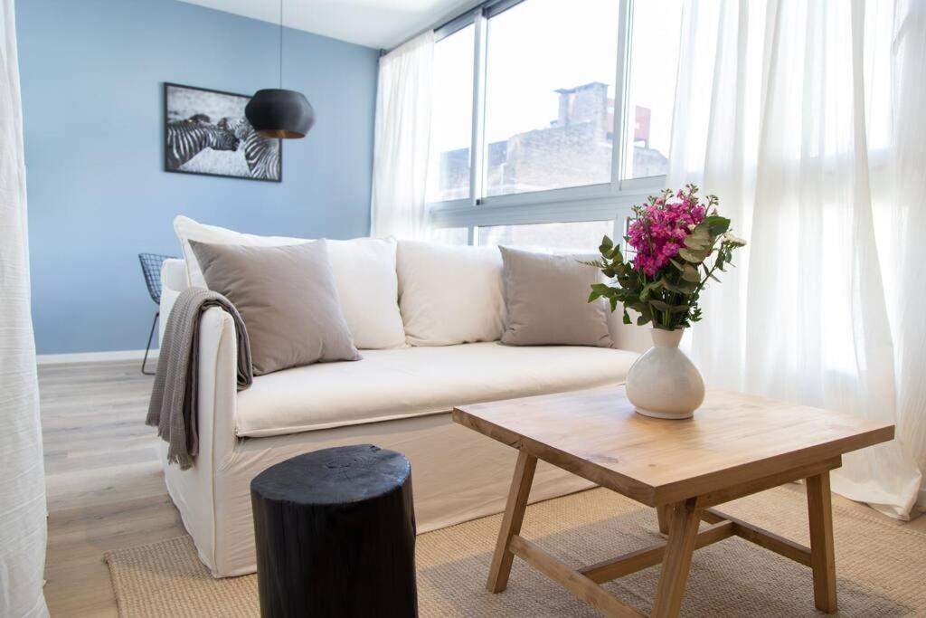 a living room with a white couch and a table at Lavanda Beautiful Apartment in Buenos Aires