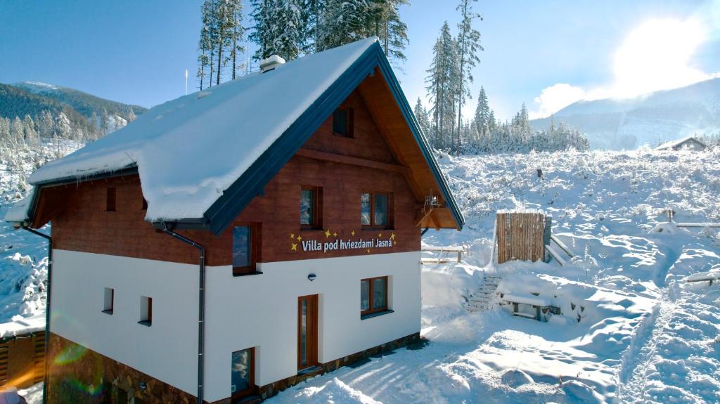 ein schneebedecktes Haus auf einem schneebedeckten Feld in der Unterkunft Villa pod hviezdami Jasná in Demänovská Dolina