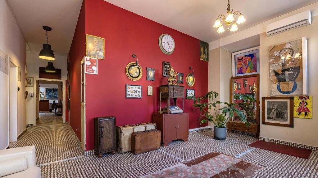 a hallway with a red wall with clocks on it at Labor Alliance Residence by LovelyStay in Lisbon