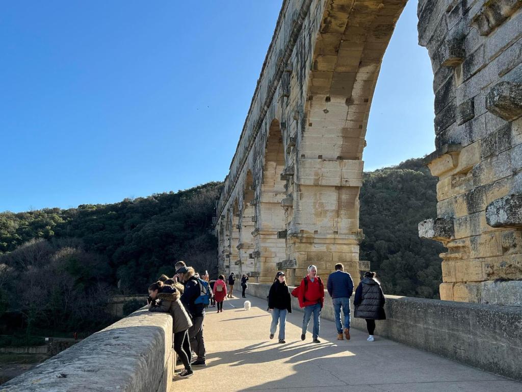 Un groupe de personnes marchant sur un pont dans l'établissement La Bastide des Pins, à Castillon-du-Gard