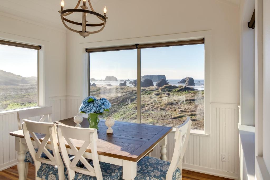 a dining room with a table and chairs with a view of the ocean at Scenic Bandon Vacation Rental with Beach Access! in Bandon