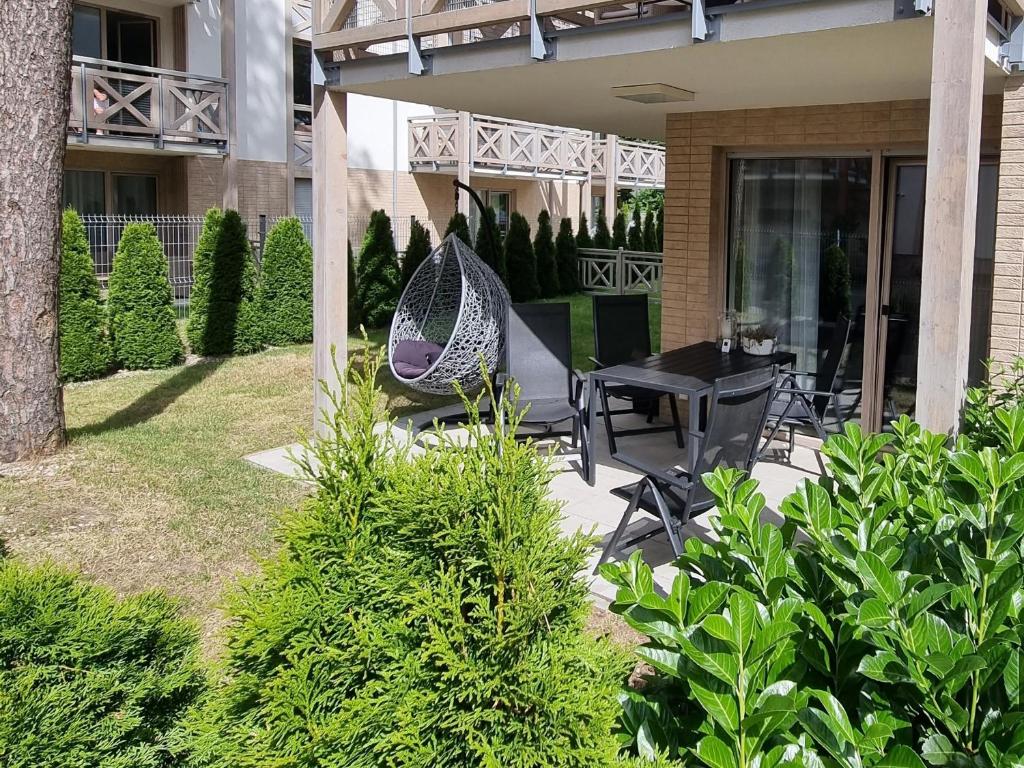 un patio con tavolo e sedie in un cortile di Apartament Turkusowy z ogrodem w Mielnie nad morzem a Mielno