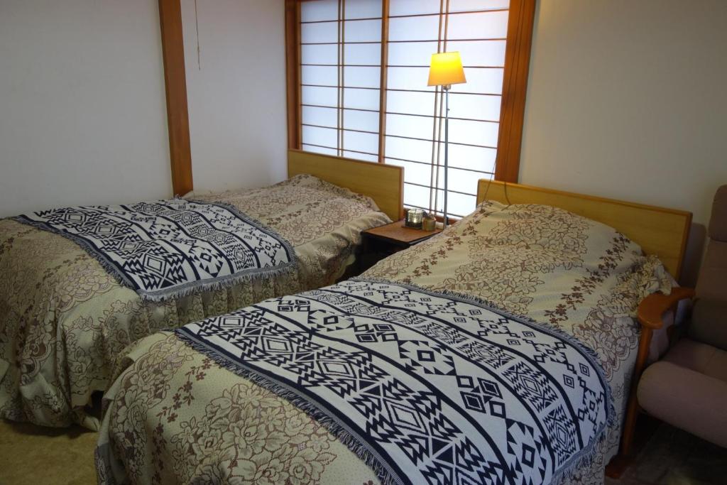 a bedroom with two beds and a window at Natural Mind Tour - Vacation STAY 56703v in Sado