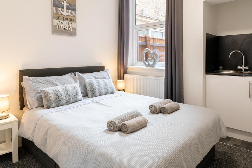 a bedroom with a bed with two towels on it at Megs Island Guest House in Cleethorpes