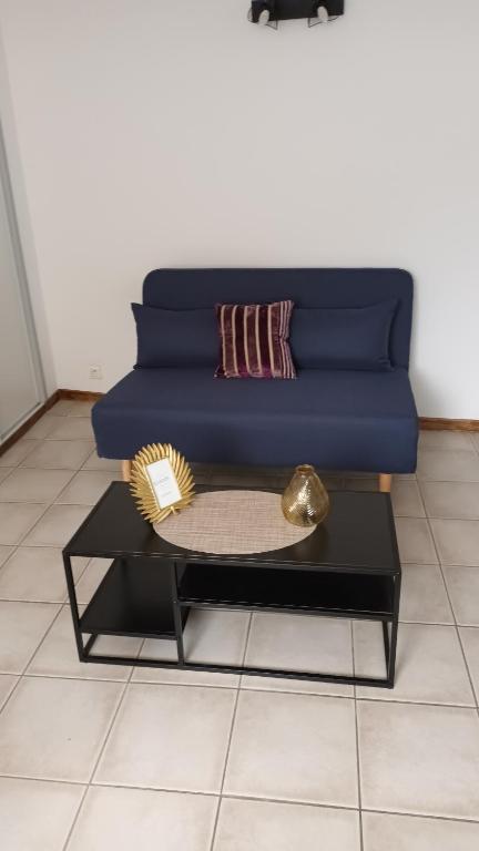 - un canapé bleu dans un salon avec une table dans l'établissement agréable T2 au centre ville, à Manosque