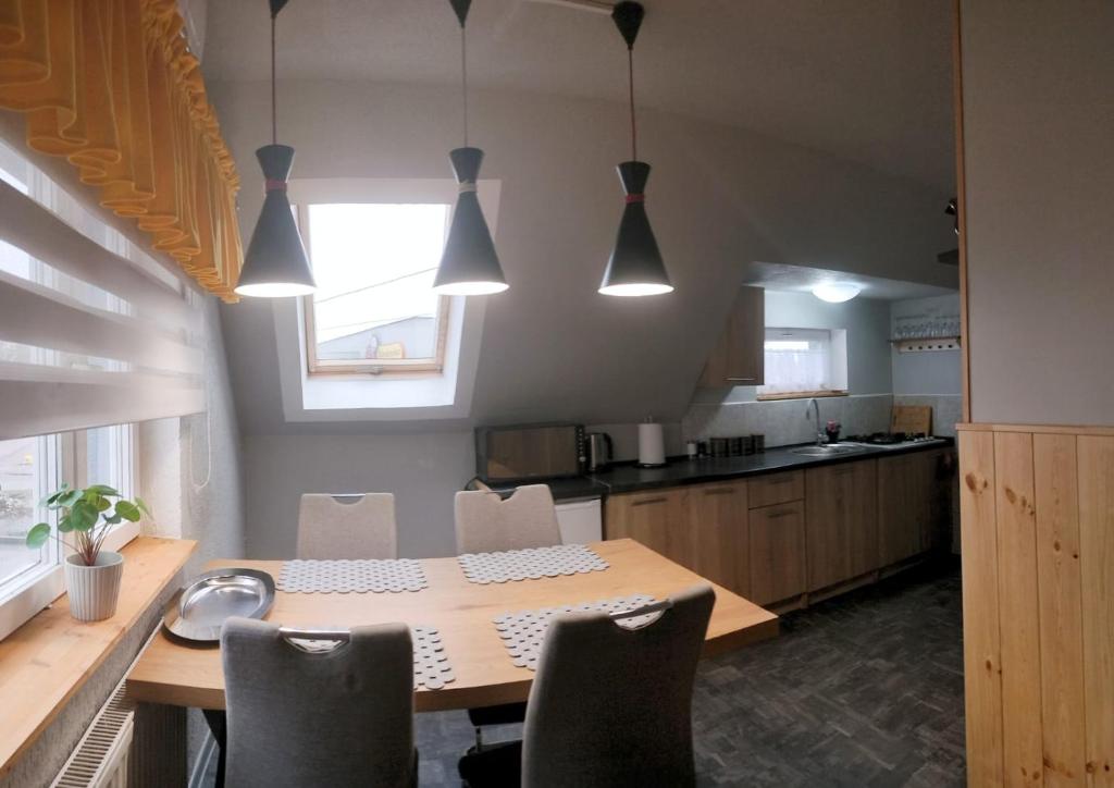 una cucina con tavolo e sedie in legno e una cucina con finestra di Apartament u Janeczki a Stepnica