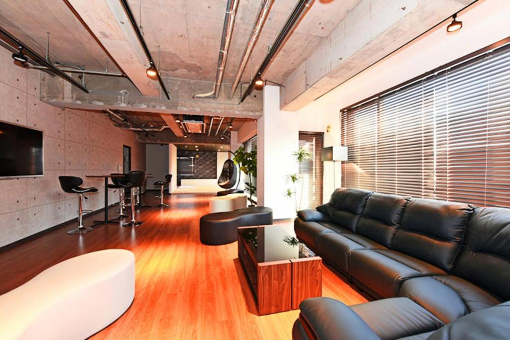 Pleasure Maruyama - Vacation STAY 52780v في سابورو: غرفة معيشة مع أريكة جلدية وطاولة