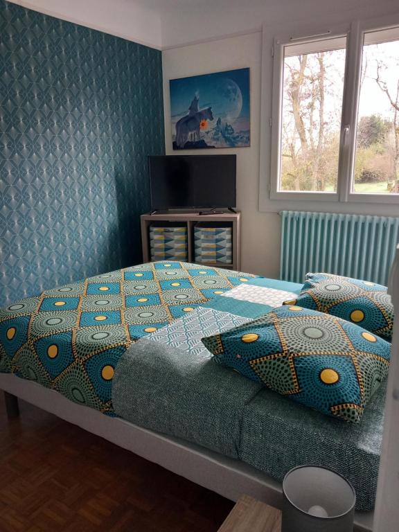 sypialnia z łóżkiem z kołdrą i poduszkami w obiekcie Les Cyclamens 1 w mieście Cosne-Cours-sur-Loire