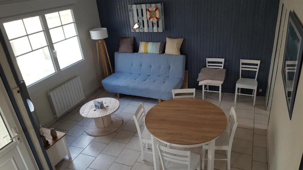 un salon avec un canapé bleu et une table dans l'établissement Duplex avec 3 chambres à 30m de la plage, à Merlimont