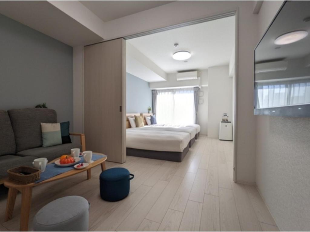 a room with a bed and a couch and a table at Eslead Hotel Namba South III - Vacation STAY 39768v in Osaka