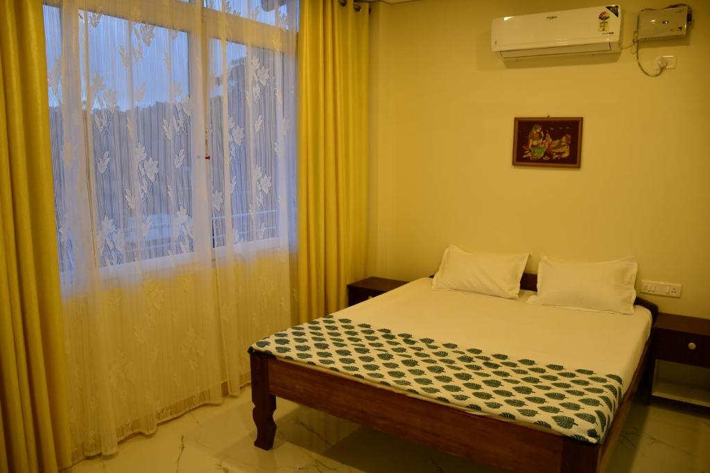 sypialnia z łóżkiem i dużym oknem w obiekcie coco view w mieście Port Blair