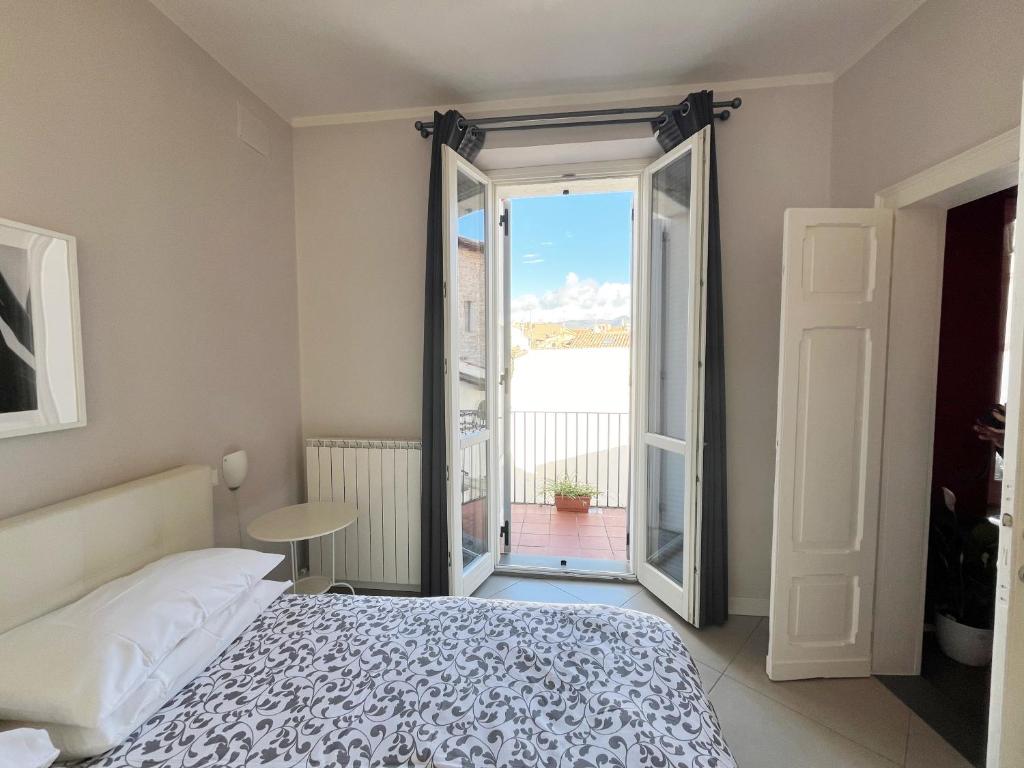 1 dormitorio con 1 cama y puerta a un balcón en "le Volte" Appartamento nel cuore di Foligno en Foligno