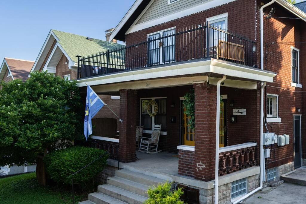 uma casa de tijolos com uma varanda e uma bandeira em Townhouse - Private 2nd Floor unit with Patio em Covington
