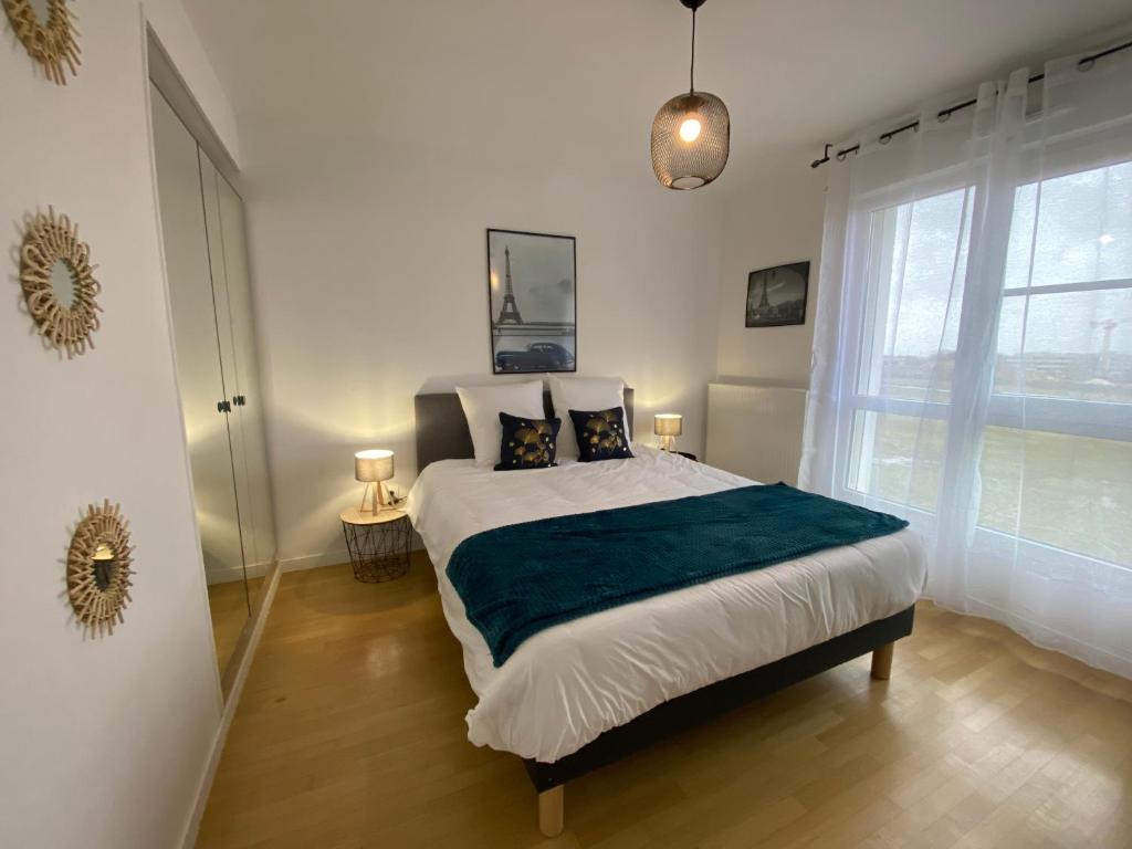 ein Schlafzimmer mit einem großen Bett mit zwei Kissen in der Unterkunft BLUE By Dream Apartments in Chessy