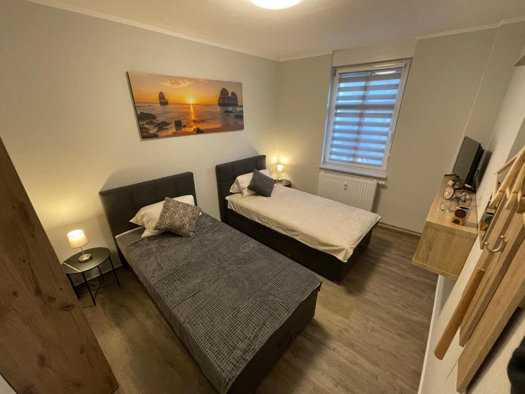 um pequeno quarto com 2 camas e um sofá em B&K Immobilien GbR em Tangermünde