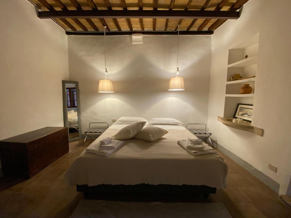 ein Schlafzimmer mit einem Bett mit zwei Kissen und zwei Lichtern in der Unterkunft Window to Bagno Vignoni in Bagno Vignoni