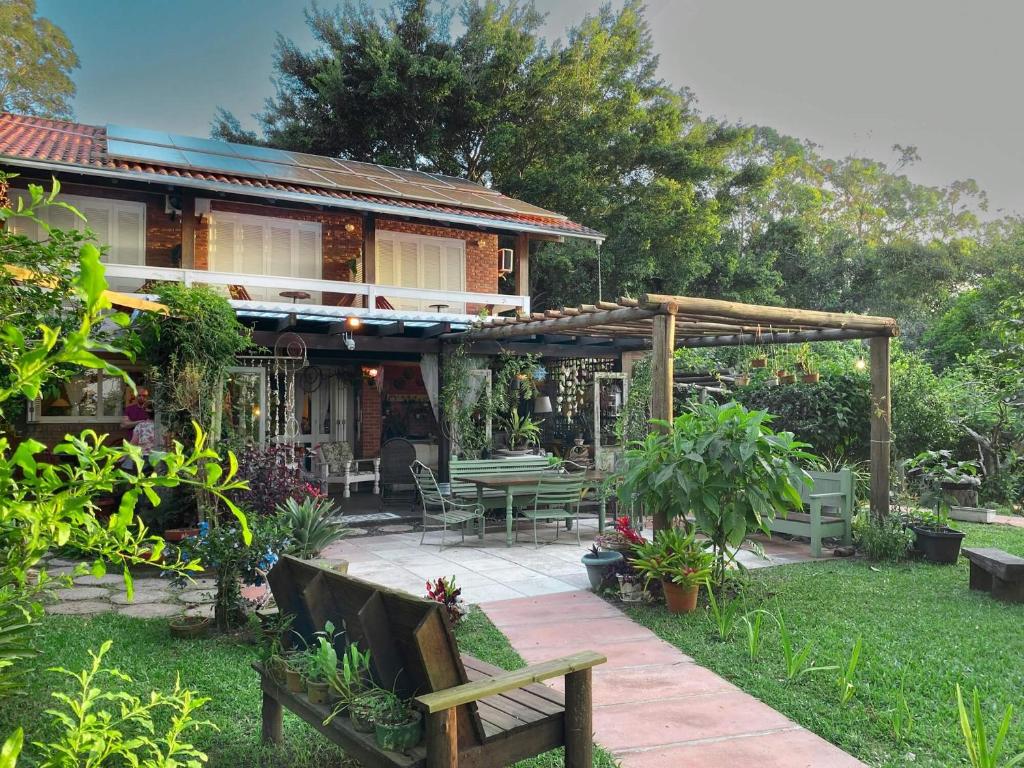 a house with a patio with a table and chairs at Morada das Bromélias in Torres