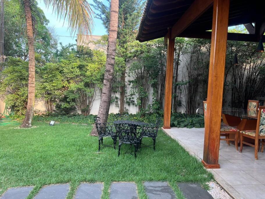 d'une terrasse avec 2 chaises et une table sur gazon. dans l'établissement Residencial Bem-te-vi, à Matão