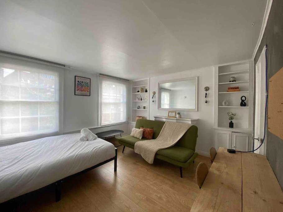 a bedroom with a bed and a couch and a chair at Flat in Kings Cross in London