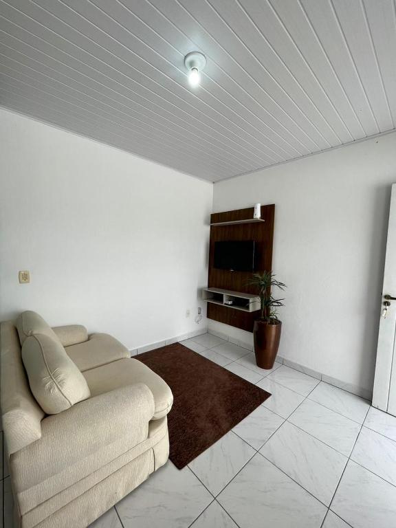 sala de estar con sofá y TV en Apartamento em Porto Belo, en Porto Belo
