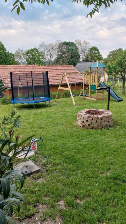 um quintal com dois baloiços e um parque infantil em Anno Apartman ll. em Balatonföldvár