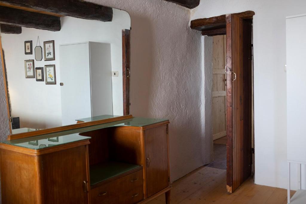 ein Ankleidezimmer mit einem Spiegel und einer Holzkommode in der Unterkunft Agriturismo Ca' Pasquin in Roccaverano