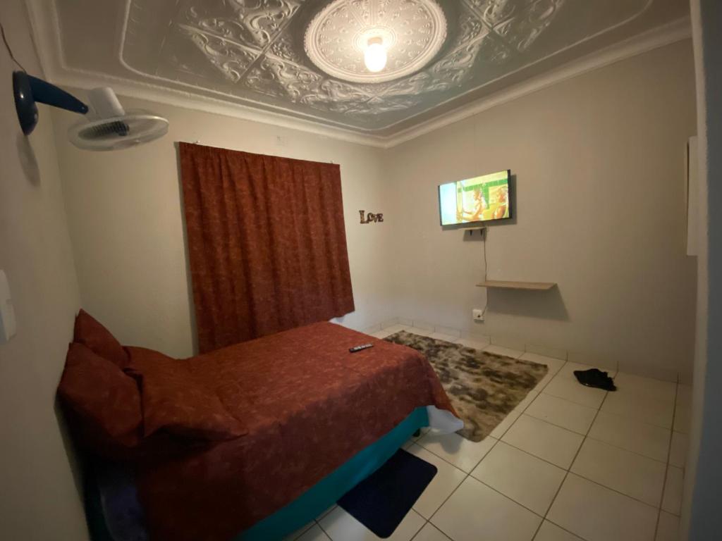 a bedroom with a bed and a flat screen tv at MOMENTS OF JOY GUESTHOUSE in Boksburg