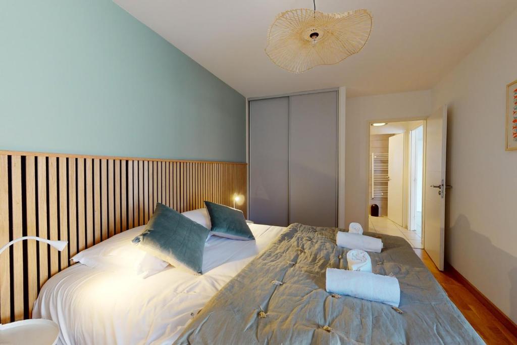 une chambre avec un grand lit avec des oreillers bleus dans l'établissement L'Equateur - 4 people garage near lake, à Annecy