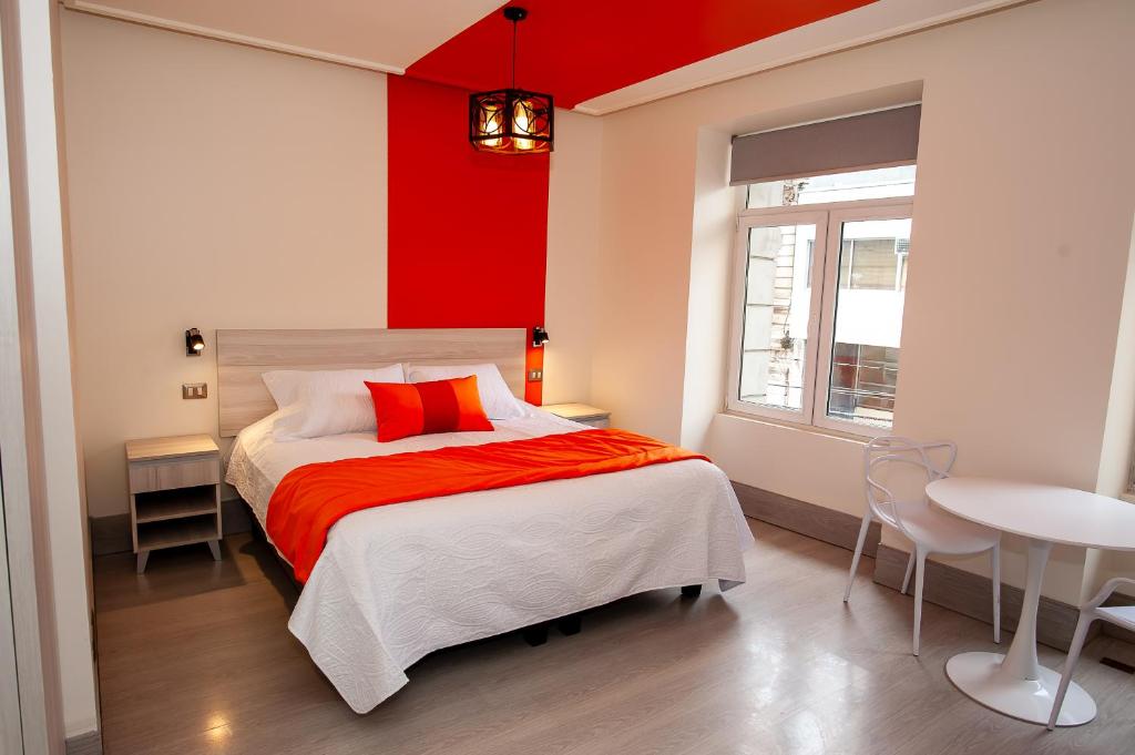 a bedroom with a bed with a red wall at Casa Esmeralda in Valparaíso