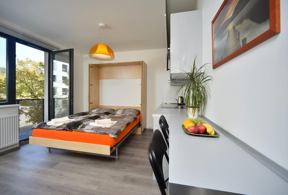 ein Schlafzimmer mit einem Bett und einem Tisch mit einer Schale Obst in der Unterkunft Appartment Waltrovka, free parking in Prag
