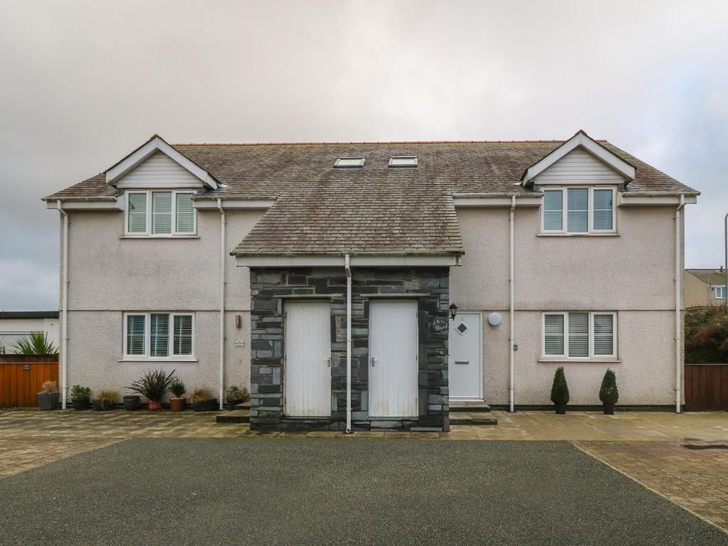 a large house with two white garage doors at Y Enciliad in Rhosneigr