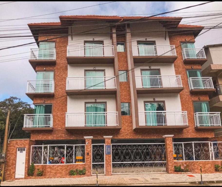 un edificio de apartamentos con balcones en una calle en Apartamento com garagem no Centro de Guaramiranga, en Guaramiranga