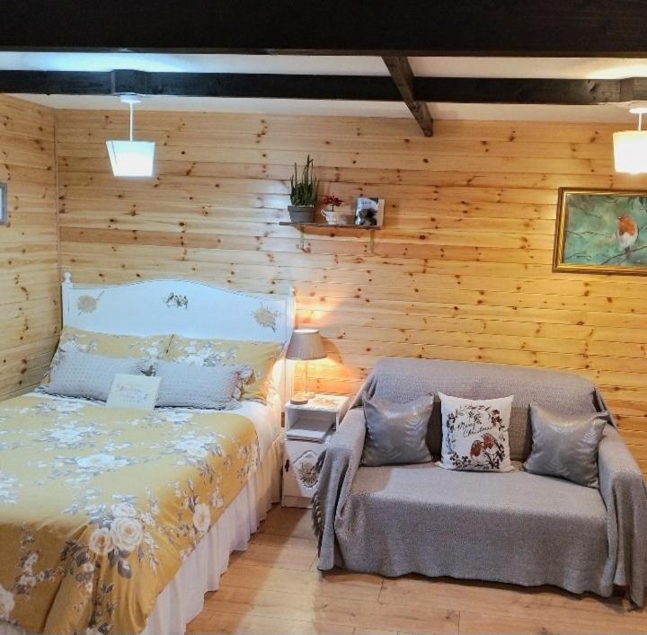 um quarto com uma cama e um banco em Robins Rest em Donegal