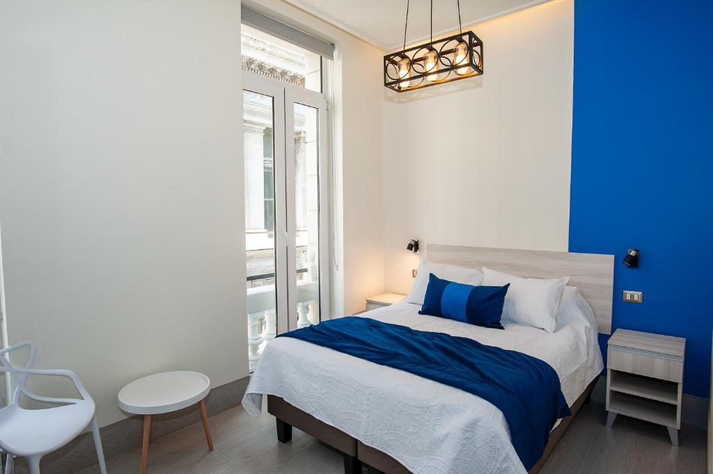 a blue and white bedroom with a bed and a chair at Casa Esmeralda in Valparaíso