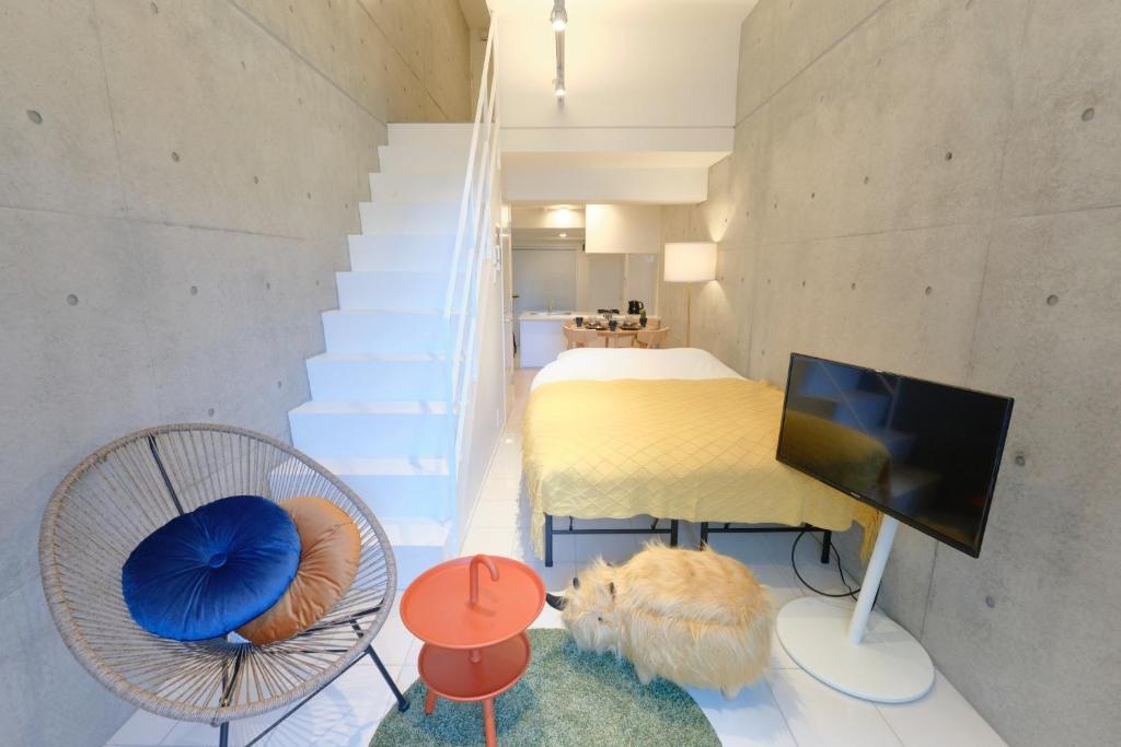 a room with a bed and a television and stairs at Toyocho SA-KU-RA - Vacation STAY 44020v in Tokyo