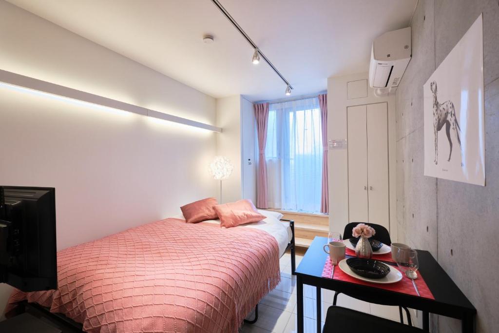 東京的住宿－Toyocho SA-KU-RA - Vacation STAY 45258v，一间卧室配有两张床和一张带一盘食物的桌子。