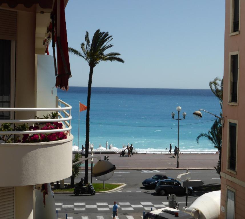 - une vue sur la plage avec un palmier et l'océan dans l'établissement Nice Centre - Apartment with balcony and stunning sea view!, à Nice