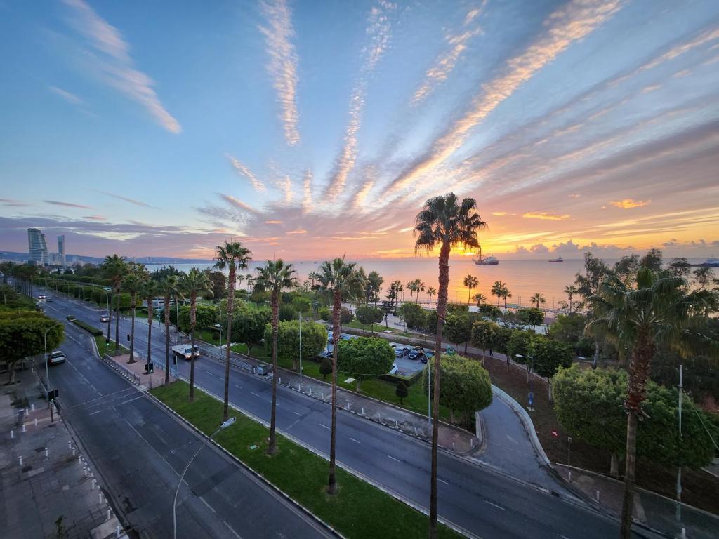 een stadsstraat met palmbomen en een zonsondergang bij Luxurious Kalypso in Limassol