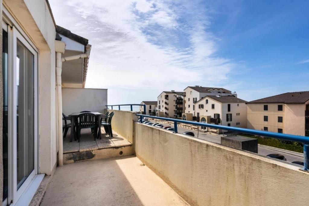 un balcon avec une table et des chaises sur un immeuble dans l'établissement Résidence Bleu Marine - maeva Home - Appartement 3 Pièces 6 Personnes vue mer - Confort MAE-5560, à Lacanau