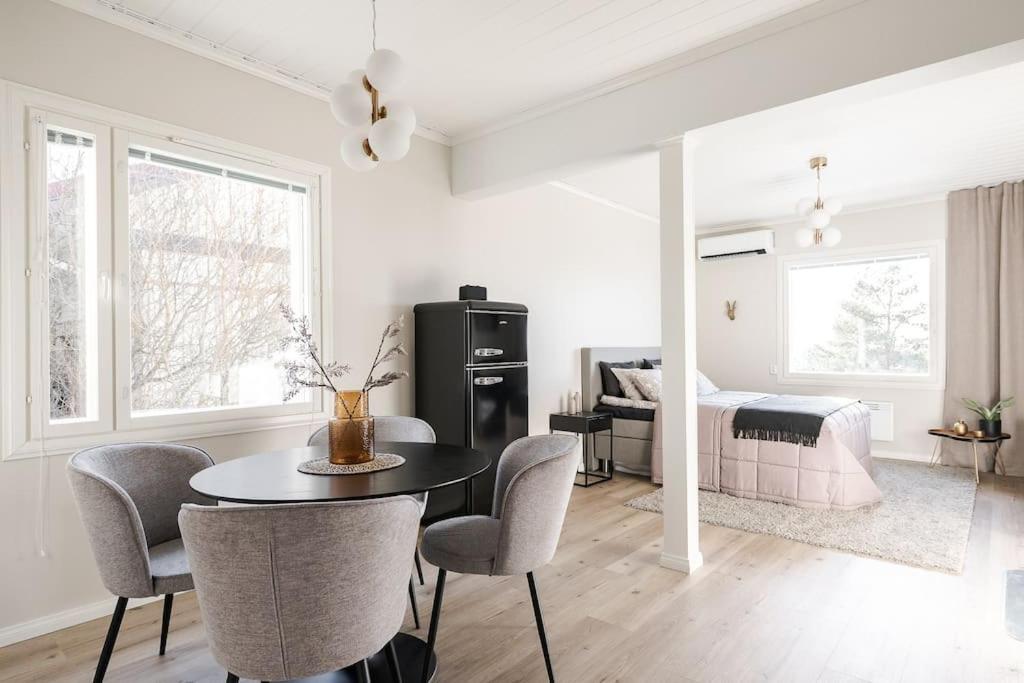 Una sala de estar con mesa y sillas y un dormitorio. en Lakeview retreat in Pispala, en Tampere