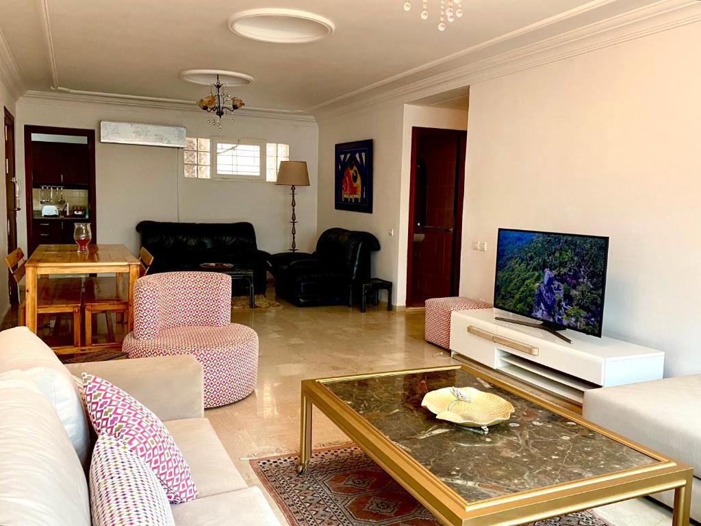a living room with a couch and a tv at Hayriad : Charmant 3 Chambres . Wifi, Smart TV in Rabat