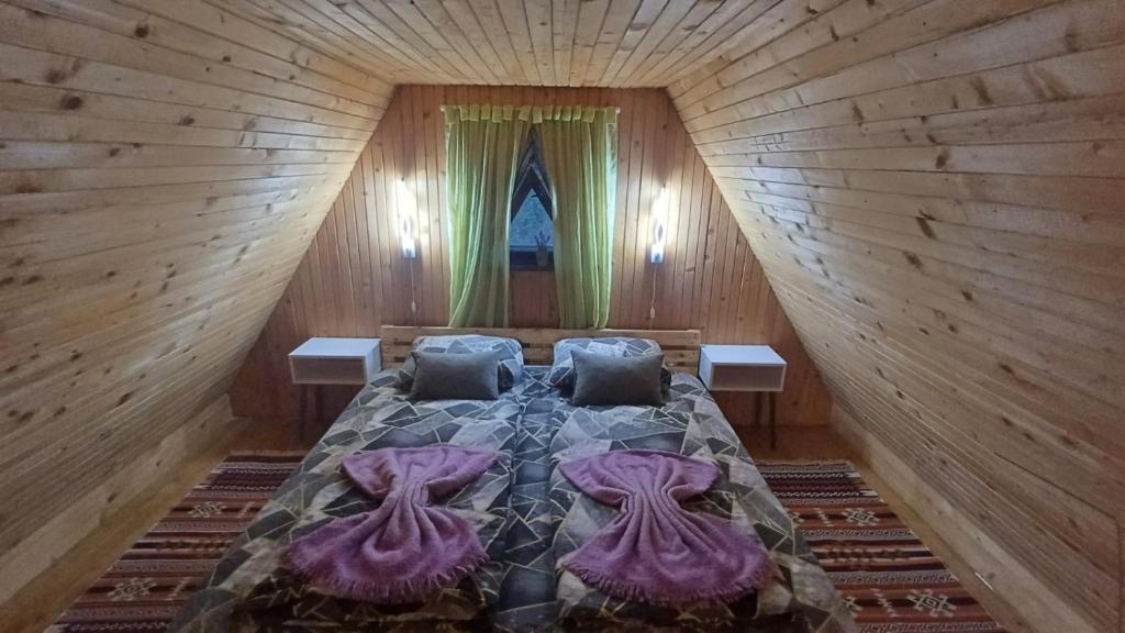 - une chambre avec un lit dans une cabane en bois dans l'établissement Forest Home, à Pale