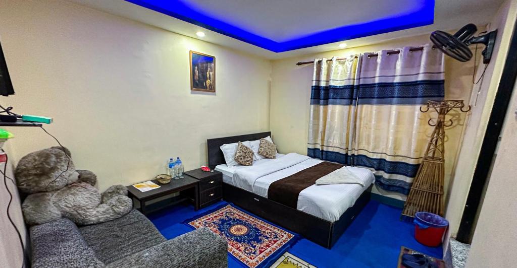 a small bedroom with a bed and a chair at Hotel Yog Darshan in Kathmandu